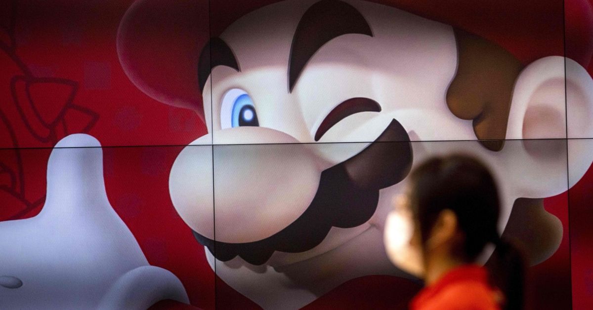An employee stands next to a screen displaying Nintendo game character Mario at a Nintendo store in Tokyo on November 5, 2020, after the gaming giant said its first-half net profit soared 243.6 percent on-year. (Photo by Behrouz MEHRI / AFP) (Photo by BEHROUZ MEHRI/AFP via Getty Images) (Behrouz Mehri/AFP via Getty Images)