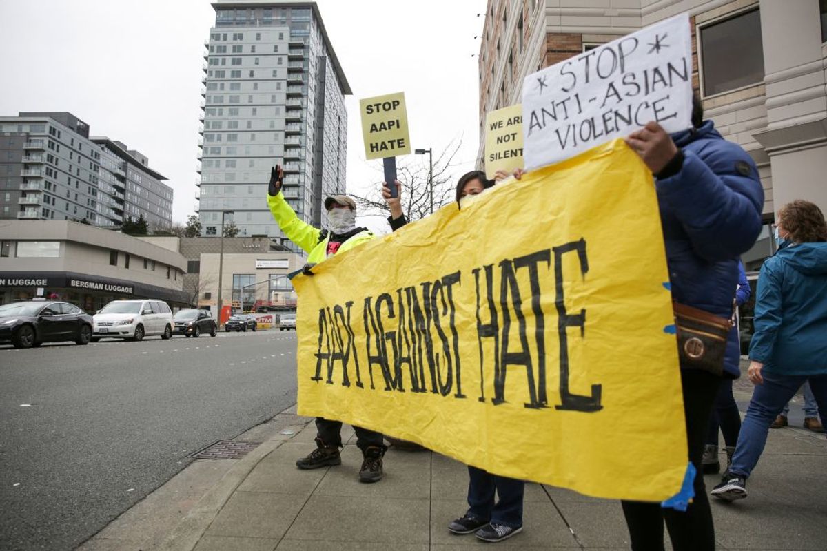 People hold signs at the intersection of Bellevue Way and 8th Street during the We Are Not Silent rally organized by the Asian American Pacific Islander (AAPI) Coalition Against Hate and Bias in Bellevue, Washington on March 18, 2021. - The shooting rampage in Atlanta by a 21-year-old white man that left six women of Asian origin dead has laid bare the fears of an Asian-American community on edge over a spike in hate crimes because of the coronavirus pandemic. (Photo by Jason Redmond / AFP) (Photo by JASON REDMOND/AFP via Getty Images) (JASON REDMOND / Getty Images)