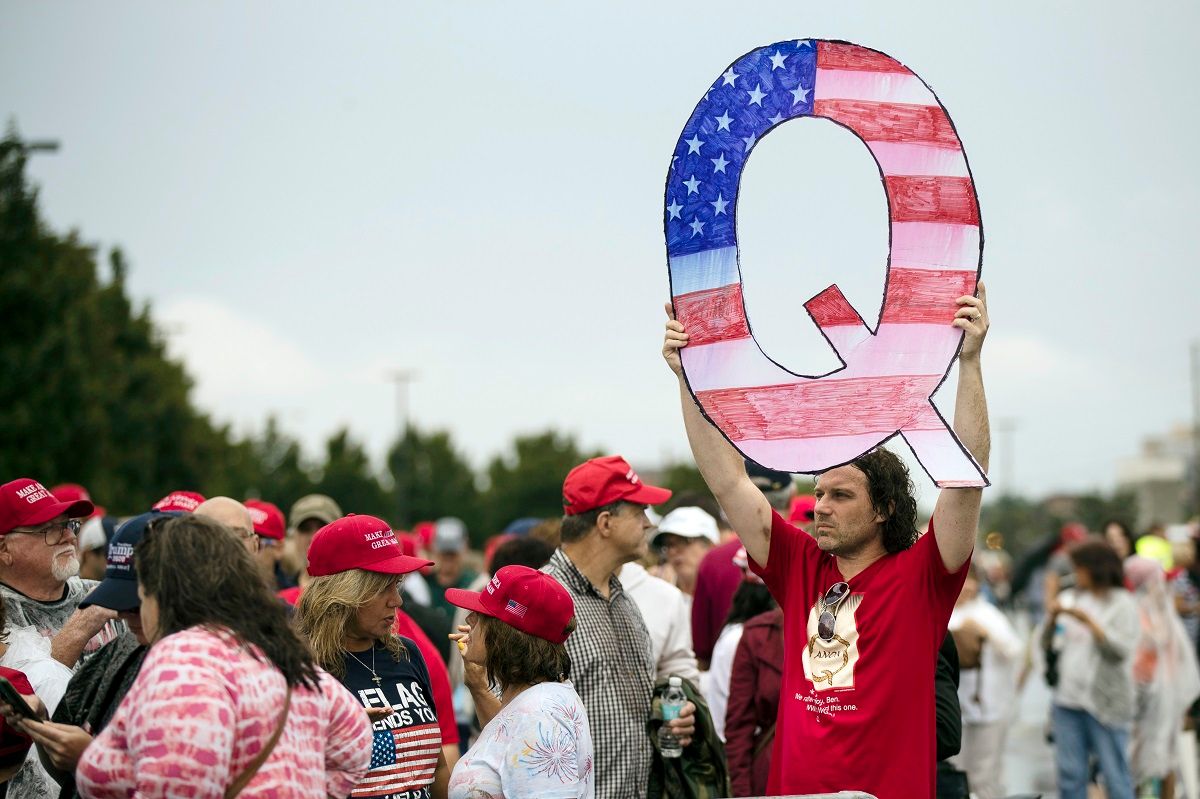 FILE - In this Aug. 2, 2018, file photo, a protesters holds a Q sign waits in line with others to enter a campaign rally with President Donald Trump in Wilkes-Barre, Pa.  Facebook says on Wednesday, Aug. 19, 2020, it will restrict QAnon and stop recommending that users join groups supporting it, but the company is stopping short of banning the right-wing conspiracy movement outright. (AP Photo/Matt Rourke, File) (AP Photo / Matt Rourke)
