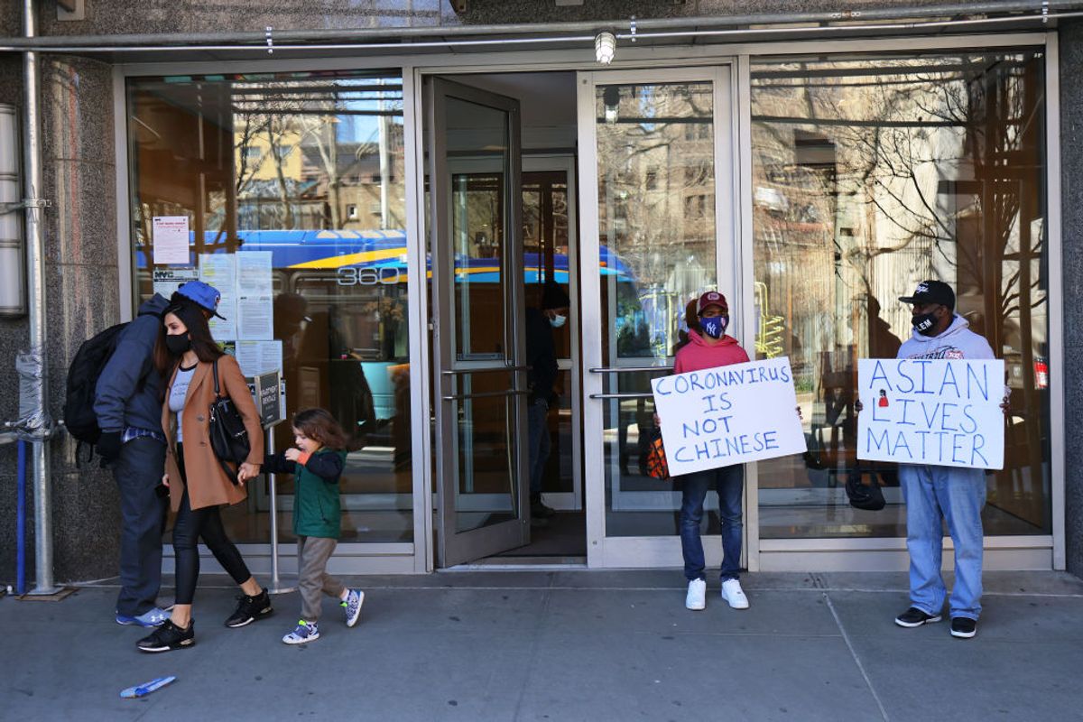 NEW YORK, NEW YORK - MARCH 30: Cameron Hunt and his father Calvin Hunt stand outside the 360 W 43rd Street building with signs of support in Midtown Manhattan on March 30, 2021 in New York City. On Monday morning, an unidentified man attacked a 65-year old woman knocking her to the ground and stomping on her head several times and made anti-Asian remarks. NYPD are calling a targeted hate crime. The victim was hospitalized with serious injuries. Brodsky Organization, which manages the luxury apartment building, have suspended staff members who witnessed the attack but failed to intervene. The attack follows a series of targeted hate crimes against people of Asian descent and has been increasing since the start of the coronavirus (COVID-19) pandemic. (Photo by Michael M. Santiago/Getty Images) (Getty Images)