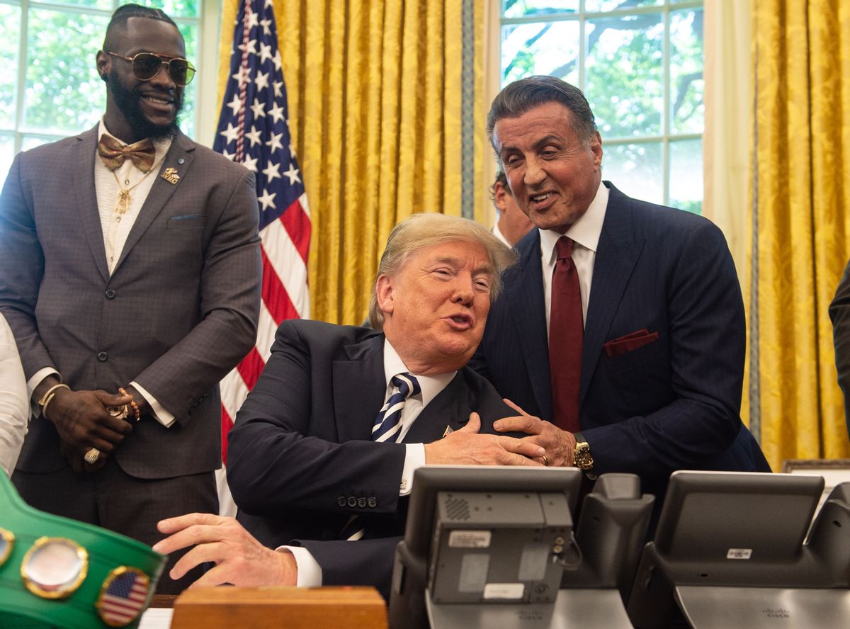 US President Donald Trump jokes with actor Sylvester Stallone(R) before signing a posthumous pardon for former world champion boxer Jack Johnson in the Oval Office at the White House in Washington, DC, on May 24, 2018, as boxer Lennox Lewis looks on. (Photo by NICHOLAS KAMM / AFP)        (Photo credit should read NICHOLAS KAMM/AFP via Getty Images) (NICHOLAS KAMM/AFP via Getty Images)