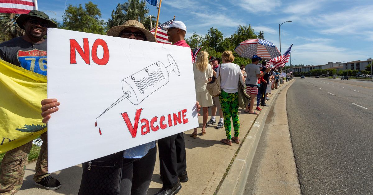 WOODLAND HILLS, CA - MAY 16: A protester holds an anti-vaccination sign as supporters of President Donald Trump rally to reopen California as the coronavirus pandemic continues to worsen, on May 16, 2020 in Woodland Hills, California. The protesters, organized by the activist group, Latinos 4 Trump 2020, are angry about restrictions related to the virus that causes COVID-19 disease and are calling for such restrictions regarding businesses, social distancing and recreational movement to end as soon as possible.  (Photo by David McNew/Getty Images) (David McNew/Getty Images)