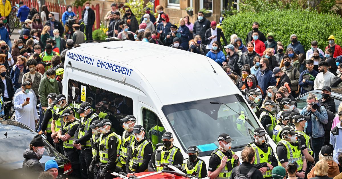 GLASGOW, SCOTLAND - MAY 13: Protestors block an immigration enforcement van, stopping it from leaving Kenmure Street in First Minister, Nicola Sturgeon's constituency on May 13, 2021 in Glsgow, Scotland. Police officers were called to Kenmure Street in Pollokshields, on the south side of the city, to support the UK Border Agency operation. (Photo by Jeff J Mitchell/Getty Images) (Jeff J Mitchell/Getty Images)