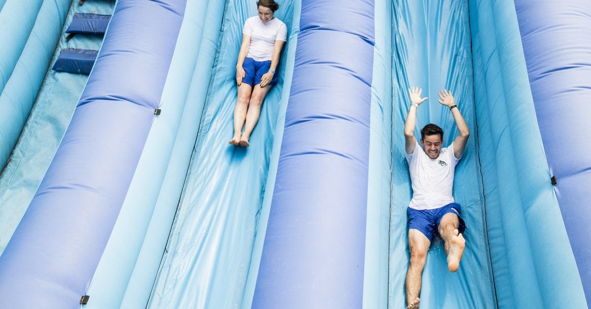 LONDON, ENGLAND - JULY 22:  Festival goers slide down Vita Coco's Slip N' Slide during Lambeth Country Show at Brockwell Park on July 22, 2018 in London, England. Vita Coco bought the UK's largest inflatable water slide to the Lambeth Country Show in a bid to help Londoners cool down during one of the hottest summers on record in the UK.  (Photo by Tristan Fewings/Getty Images for Vita Coco) (Tristan Fewings/Getty Images for Vita Coco)