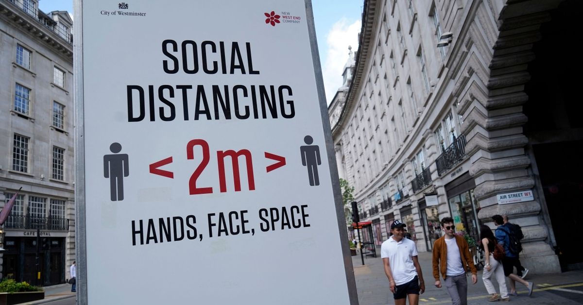 Pedestrians walk past a sign asking members of the public to social distance due to Covid-19, in central London on June 7, 2021. - The Delta variant of the coronavirus, first discovered in India, is estimated to be 40 percent more transmissible than the Alpha variant that caused the last wave of infections in the UK, Britain's health minister said Sunday. (Photo by Niklas HALLE'N / AFP) (Photo by NIKLAS HALLE'N/AFP via Getty Images) (Getty Images)