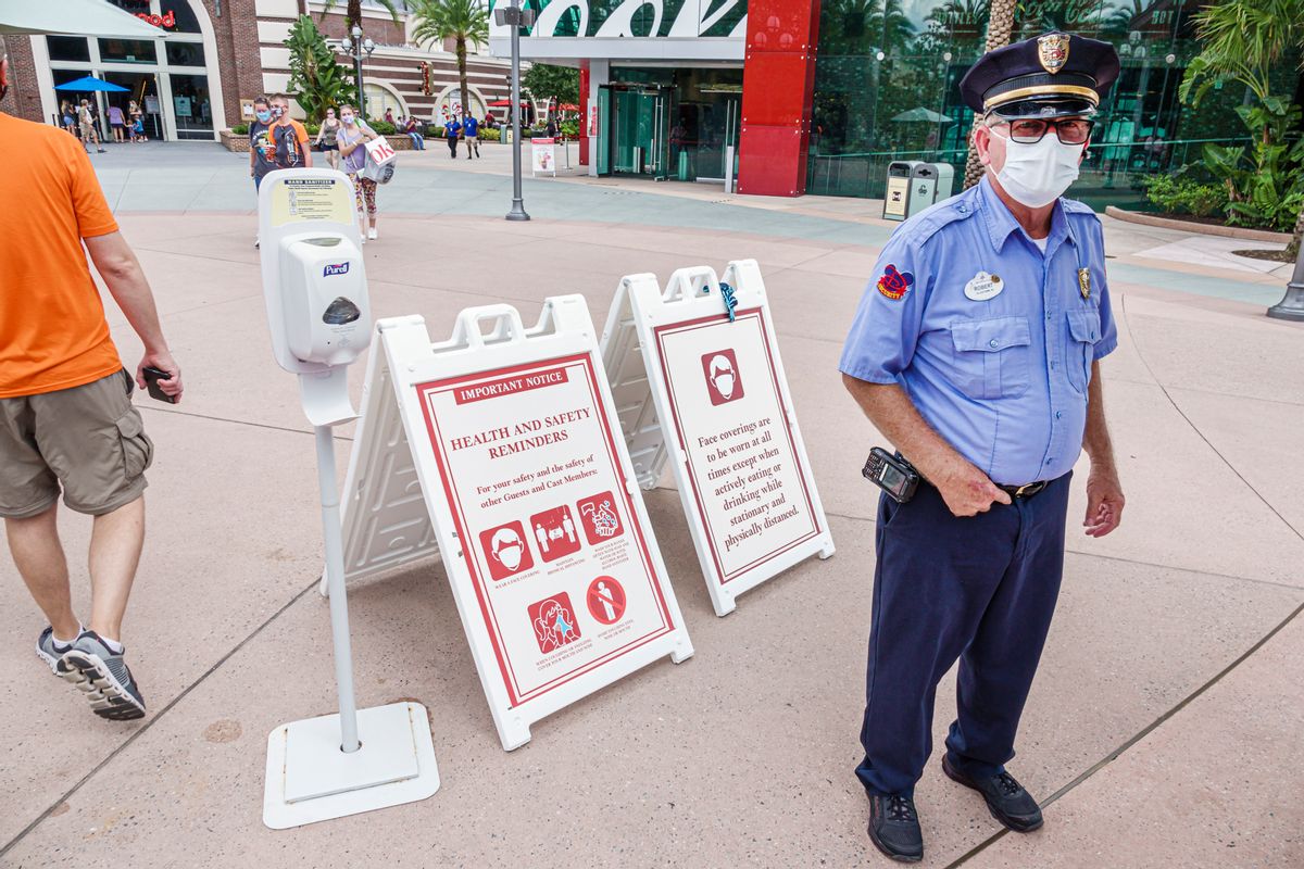 Florida, Orlando, Walt Disney World Resort, security guard, near health safety reminders and Purell hand sanitizing stand. (Photo by: Jeffrey Greenberg/Education Images/Universal Images Group via Getty Images) (Getty Images)