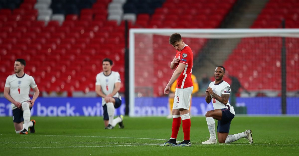 LONDON, ENGLAND - MARCH 31: Krzysztof Piatek of Poland points to his respect badge as Raheem Sterling of England takes a knee in support of the Black Lives Matter movement prior to the FIFA World Cup 2022 Qatar qualifying match between England and Poland on March 31, 2021 at Wembley Stadium in London, England. Sporting stadiums around the UK remain under strict restrictions due to the Coronavirus Pandemic as Government social distancing laws prohibit fans inside venues resulting in games being played behind closed doors. (Photo by Catherine Ivill/Getty Images) (Catherine Ivill/Getty Images)