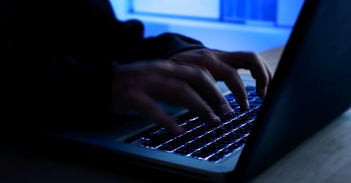 A computer programmer or hacker prints a code on a laptop keyboard to break into a secret organization system. Internet crime concept. (Getty Images)