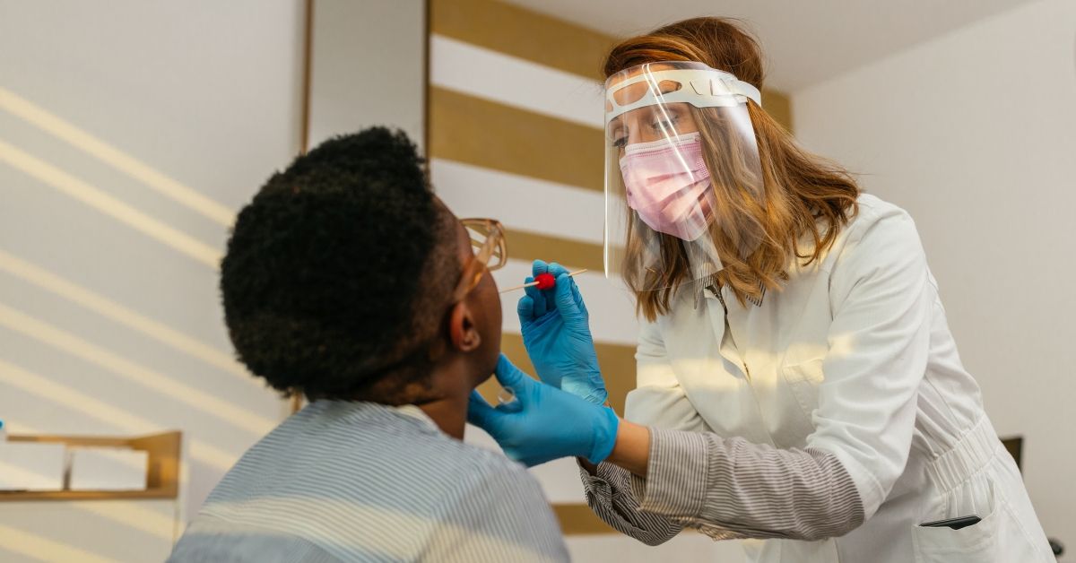 Doctor in a protective suit taking a throat swab from a patient to test for possible coronavirus infection (Getty Images/Stock photo)