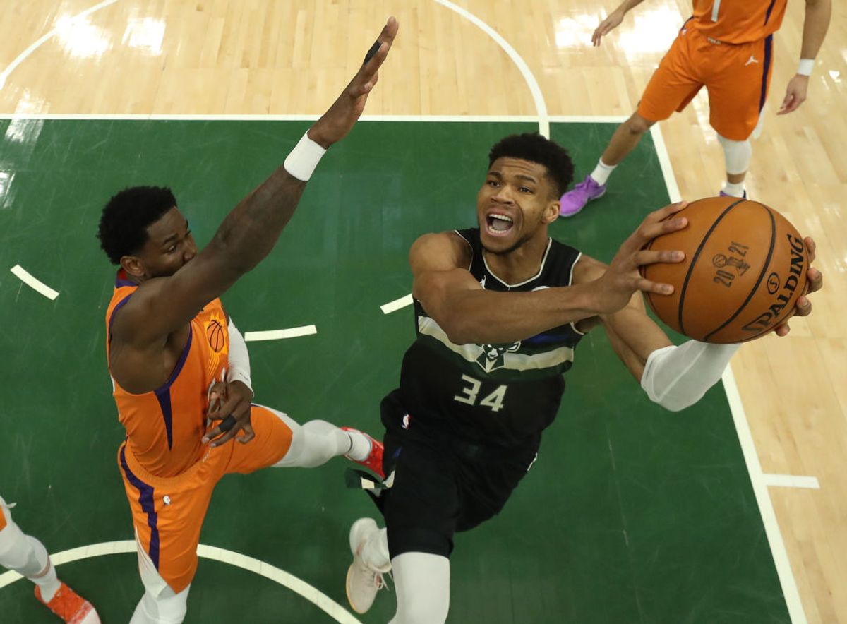 MILWAUKEE, WISCONSIN - JULY 20: Giannis Antetokounmpo #34 of the Milwaukee Bucks goes up for a shot  against Deandre Ayton #22 of the Phoenix Suns during the second half in Game Six of the NBA Finals at Fiserv Forum on July 20, 2021 in Milwaukee, Wisconsin. NOTE TO USER: User expressly acknowledges and agrees that, by downloading and or using this photograph, User is consenting to the terms and conditions of the Getty Images License Agreement.  (Photo by Justin Casterline/Getty Images) (Getty Images)