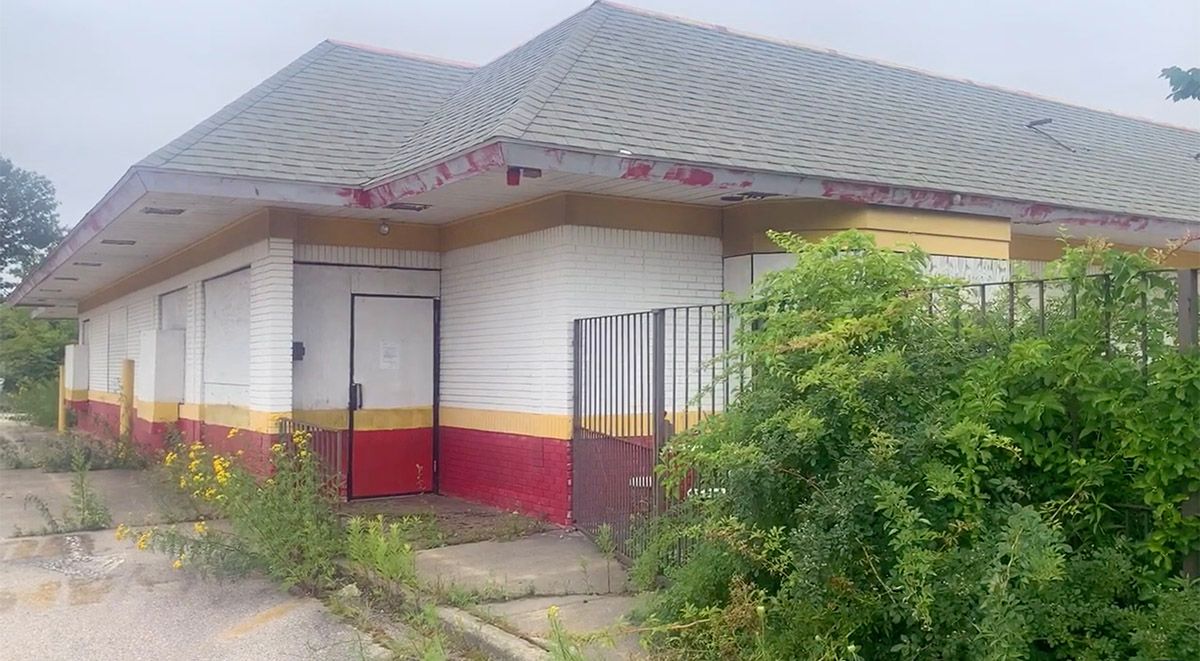 The outside of the abandoned McDonald's is overgrown with weeds and bushes. (Courtesy: Triangle of Mass/YouTube) (@triangleofmass/TikTok)