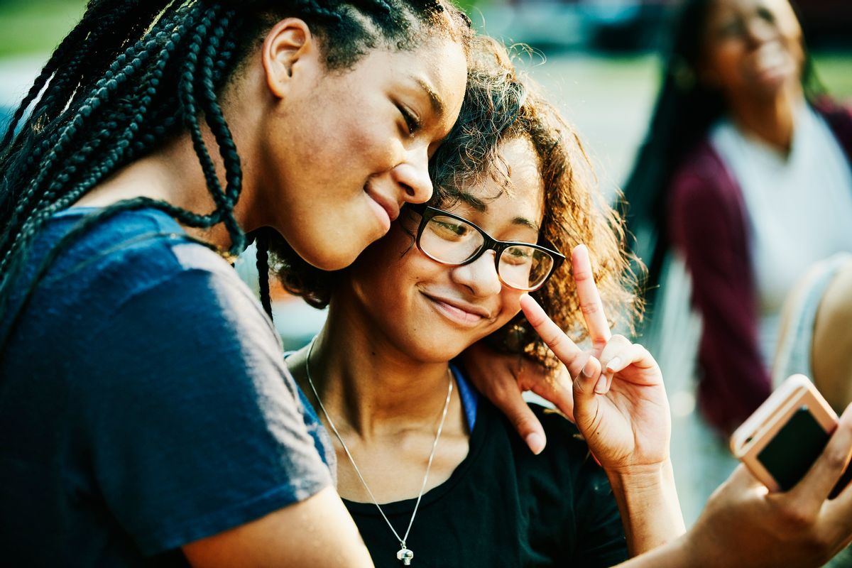 Smiling teenage friends taking selfie with smartphone on summer evening (Getty Images/Stock photo)
