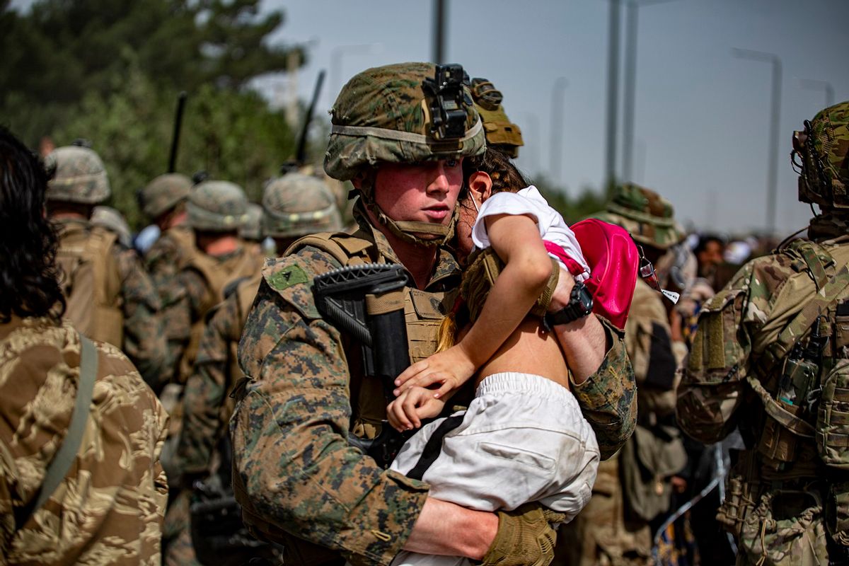 210820-M-TT571-2137 HAMID KARZAI INTERNATIONAL AIRPORT, Afghanistan (August 20, 2021) A Marine assigned to the 24th Marine Expeditionary Unit carries a girl at a gate to Hamid Karzai International Airport, Aug. 20. U.S. service members are assisting the Department of State with a Non-Combatant Evacuation operation (NEO) in Afghanistan. (U.S. Marine Corps photo by 1stLt. Mark Andries) ( U.S. Marine Corps/Wikimedia Commons)