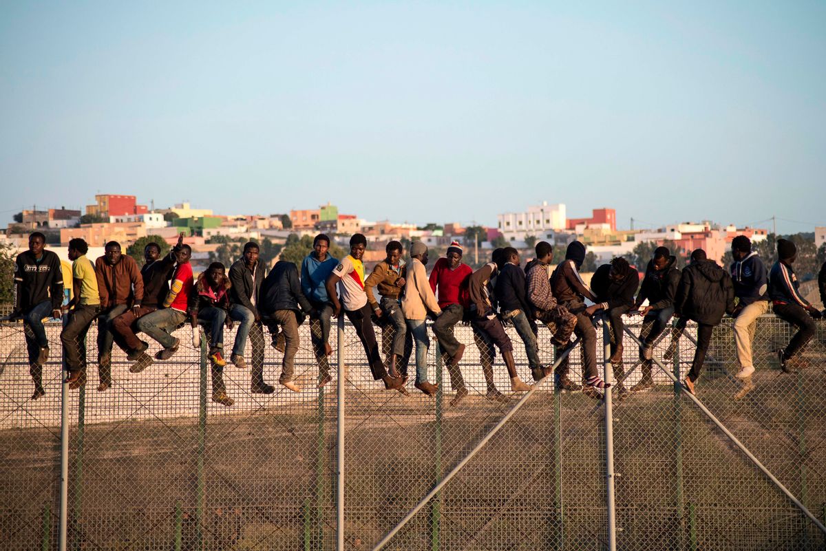 Would-be immigrants stand atop a boarder fence separating Morocco from the north African Spanish enclave of Melilla on October 22, 2014, following a morning assault on the boarder in an attempt to cross into Spain. The flow of migrants scrambling to reach Spain's north African territory Melilla is at double the rate of last year, an official said on October 21 as he defended police after a video showed abuse by border guards. The head of the Spanish government delegation in the territory, Abdelmalik El Barkani, said the number of attempts by desperate migrants to scale the seven-metre (23-foot), triple-layer fence separating Melilla from Morocco has surged in 2014.    AFP PHOTO/ BLASCO AVELLANEDA (Photo by Jesus BLASCO DE AVELLANEDA / AFP) (Photo by JESUS BLASCO DE AVELLANEDA/AFP via Getty Images) (JESUS BLASCO DE AVELLANEDA/AFP via Getty Images)