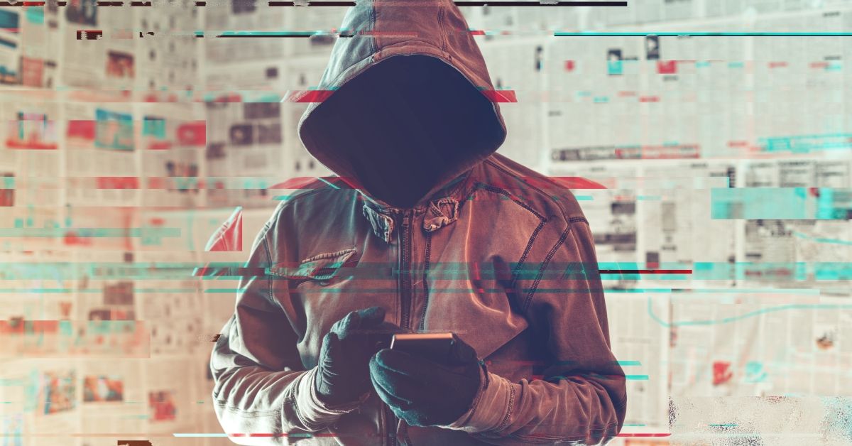 Hooded hacker person using smartphone in infodemic concept with digital glitch effect (Getty Images/Stock photo)