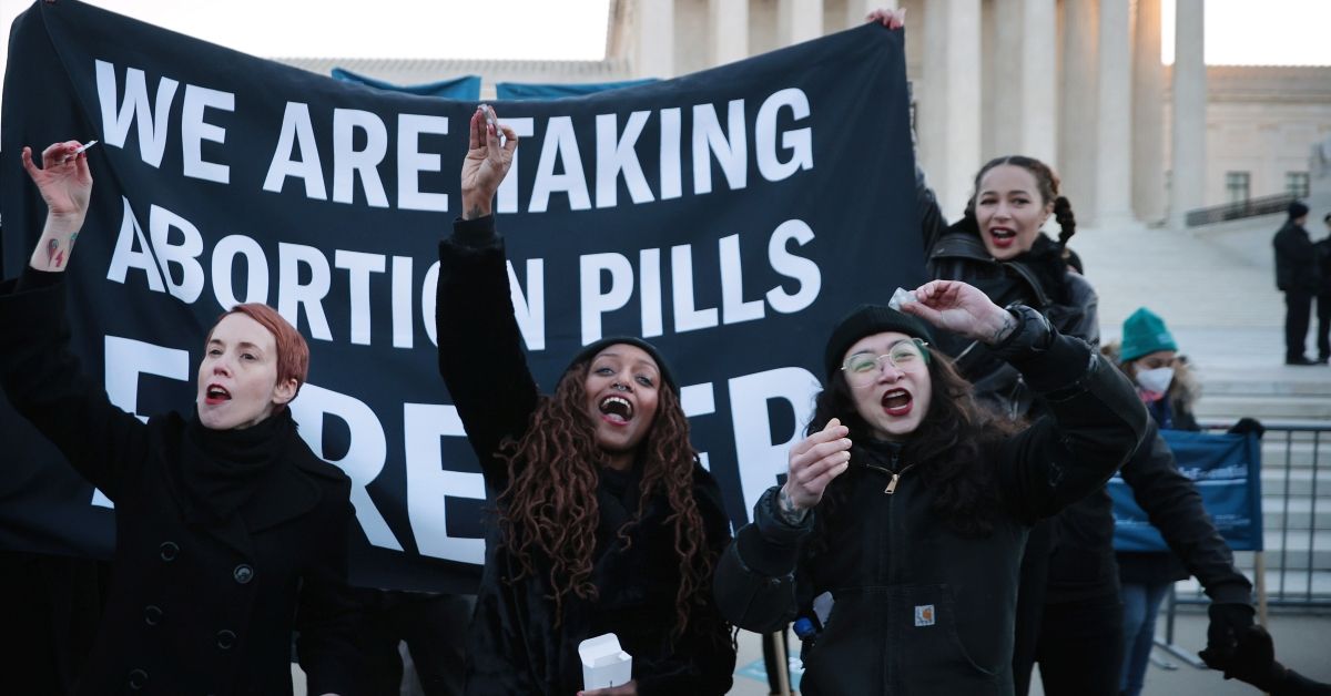 WASHINGTON, DC - DECEMBER 01: (L-R) Lila Bonow, Alana Edmondson and Aiyana Knauer prepare to take abortion pill while demonstrating in front of the U.S. Supreme Court as the justices hear hear arguments in Dobbs v. Jackson Women's Health, a case about a Mississippi law that bans most abortions after 15 weeks,  on December 01, 2021 in Washington, DC. With the addition of conservative justices to the court by former President Donald Trump, experts believe this could be the most important abortion case in decades and could undermine or overturn Roe v. Wade. (Photo by Chip Somodevilla/Getty Images) (Chip Somodevilla/Getty Images)