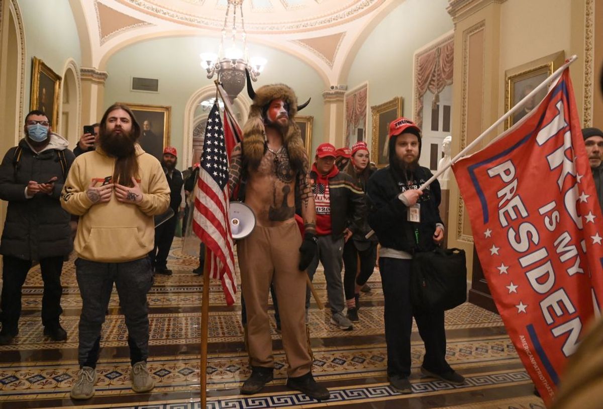 TOPSHOT - Supporters of US President Donald Trump, including member of the QAnon conspiracy group Jake Angeli, aka Yellowstone Wolf (C), enter the US Capitol on January 6, 2021, in Washington, DC. - Demonstrators breeched security and entered the Capitol as Congress debated the a 2020 presidential election Electoral Vote Certification. (Photo by Saul LOEB / AFP) (Photo by SAUL LOEB/AFP via Getty Images) (Getty Images)
