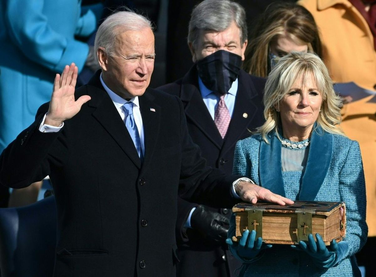 TOPSHOT - Joe Biden, flanked by incoming US First Lady Jill Biden takes the oath of office as the 46th US President by Supreme Court Chief Justice John Roberts during the swearing-in ceremony of the 46th US President on January 20, 2021, at the US Capitol in Washington, DC. (Photo by Brendan SMIALOWSKI / AFP) (Photo by BRENDAN SMIALOWSKI/AFP via Getty Images) (Brendan Smialowski/AFP via Getty Images)