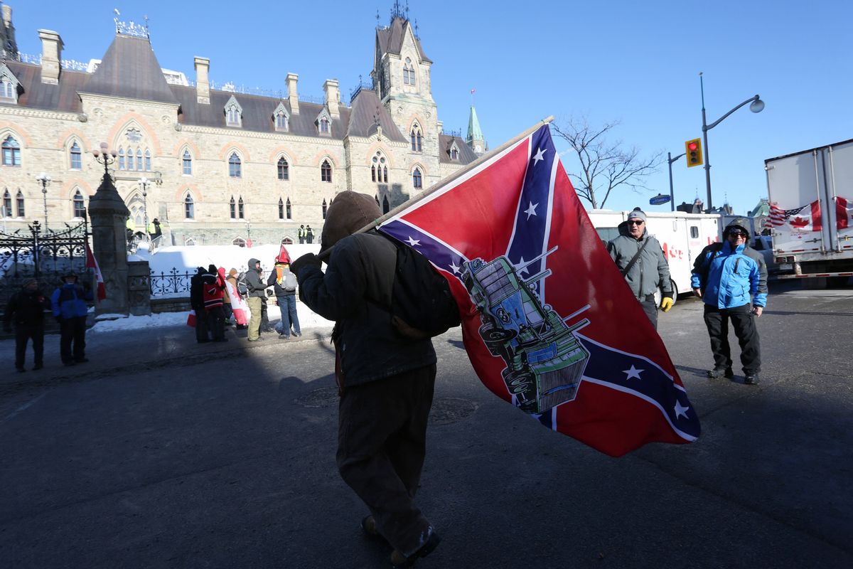 A supporter carries a US Confederate flag during the Freedom Convoy protesting  Covid-19 vaccine mandates and restrictions in front of Parliament on January 29, 2022 in Ottawa, Canada. - Hundreds of truckers drove their giant rigs into the Canadian capital Ottawa on Saturday as part of a self-titled "Freedom Convoy" to protest vaccine mandates required to cross the US border. (Photo by Dave Chan / AFP) (Photo by DAVE CHAN/AFP via Getty Images) (DAVE CHAN/AFP via Getty Images)