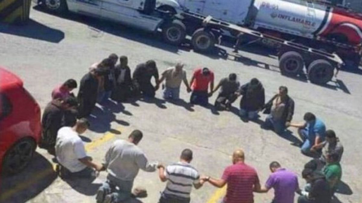 A picture of a trucker prayer circle showed men near trucks praying purportedly near the Canada or Canadian border in 2022 but actually showed Honduras in 2020. (Instituto Hondureño del Transporte Terrestre (Facebook))