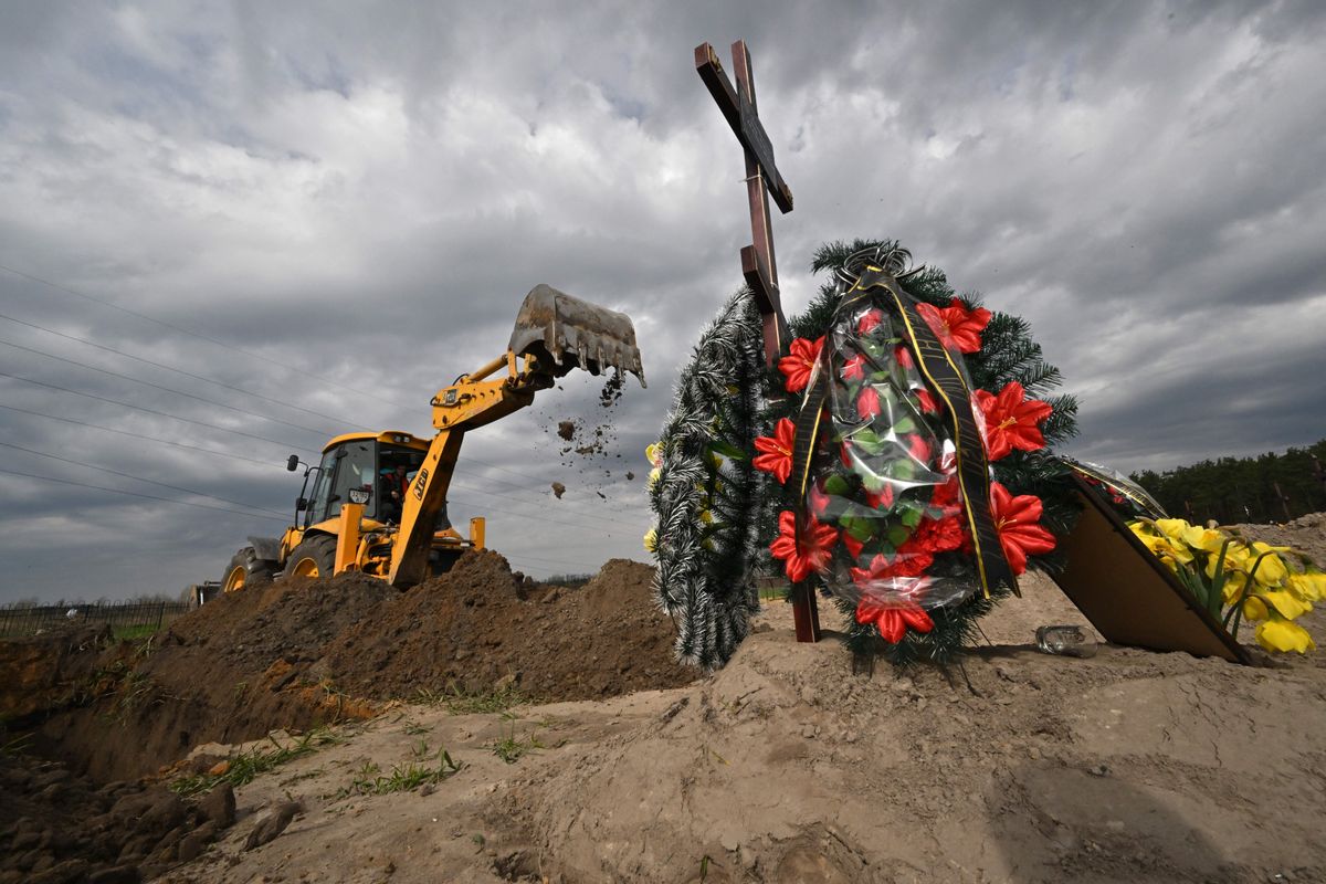 An excavator digs new graves in the special part of the cemetery for the civilian people killed since the start of Russian invasion on April 25, 2022 in Bucha, Kyiv region. (Photo by Sergei SUPINSKY / AFP) (Photo by SERGEI SUPINSKY/AFP via Getty Images) (Getty Images)