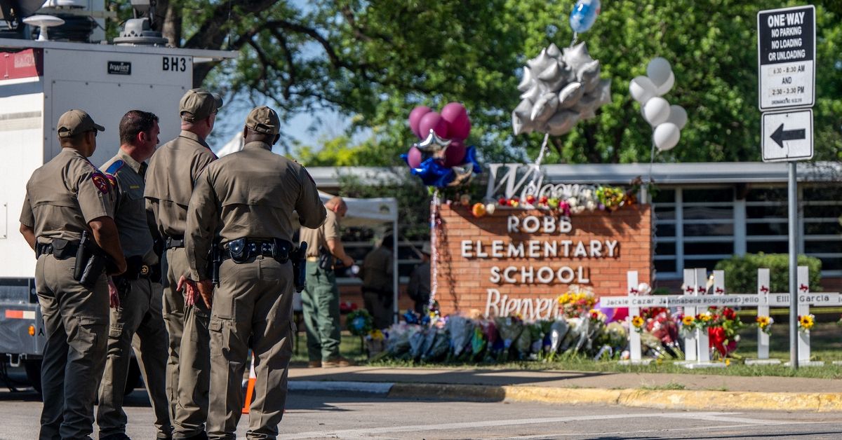 UVALDE, TEXAS - MAY 26: Law enforcement officers stand looking at a memorial following a mass shooting at Robb Elementary School on May 26, 2022 in Uvalde, Texas. According to reports, 19 students and 2 adults were killed, with the gunman fatally shot by law enforcement. (Photo by Brandon Bell/Getty Images) (Brandon Bell/Getty Images)