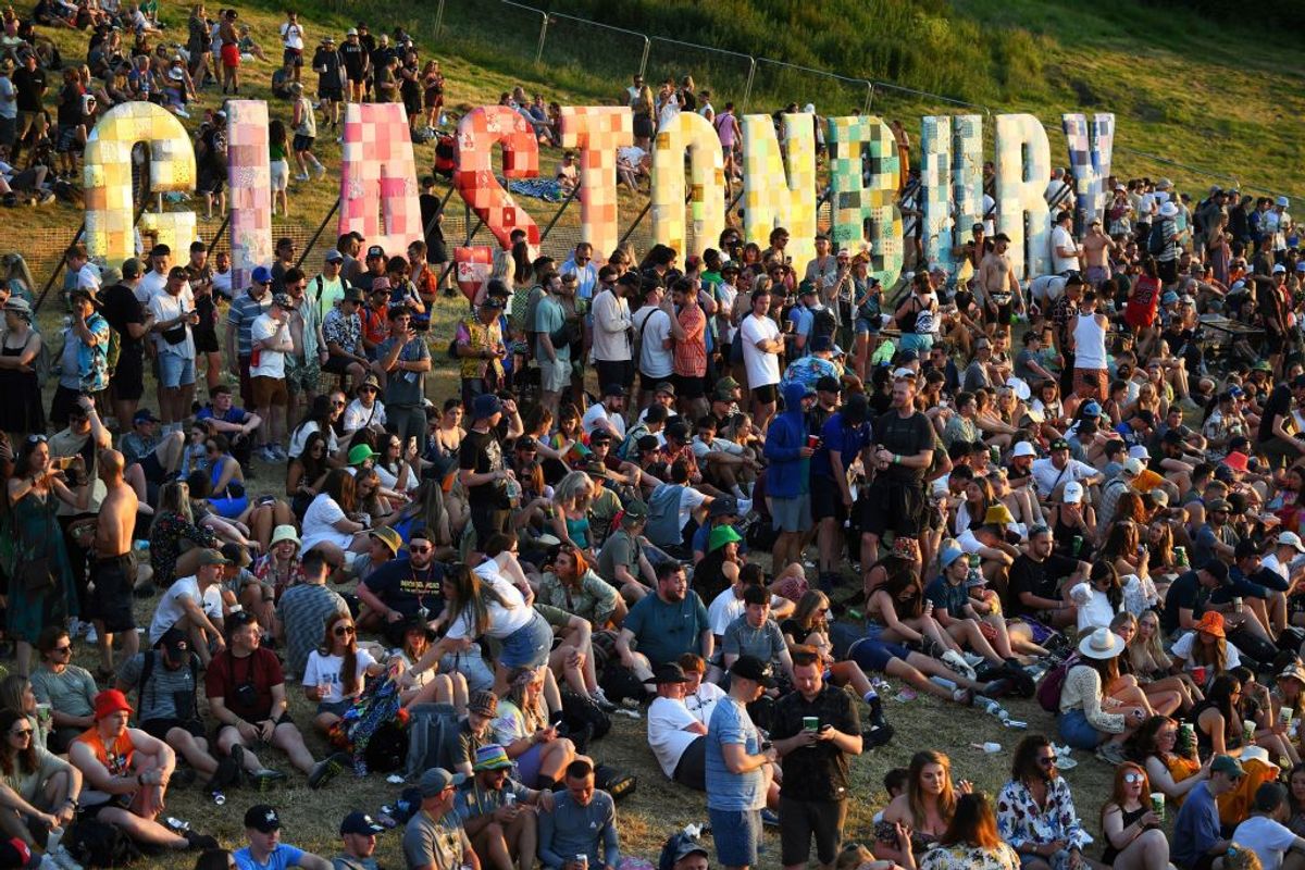 TOPSHOT - Festivalgoers attend the Glastonbury festival near the village of Pilton in Somerset, southwest England, on June 22, 2022. - More than 200,000 music fans and megastars Paul McCartney, Billie Eilish and Kendrick Lamar descend on the English countryside this week as Glastonbury Festival returns after a three-year hiatus. The coronavirus pandemic forced organisers to cancel the last two years' events, and those going this year face an arduous journey battling three days of major rail strikes across the country. (Photo by Andy Buchanan / AFP) (Photo by ANDY BUCHANAN/AFP via Getty Images) (Getty Images)