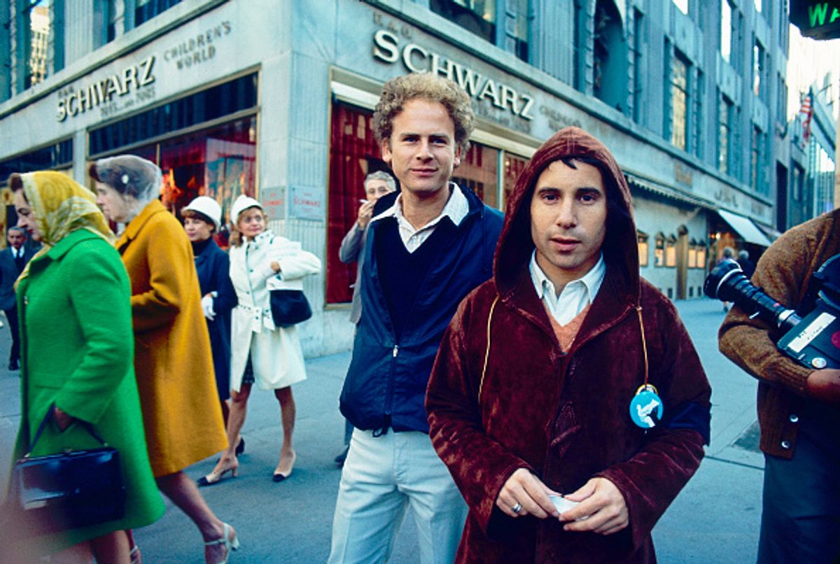Portrait of American Folk and Pop musicians Art Garfunkel (center) and Paul Simon (in hood) stand on the corner of 5th Avenue and E 58th Street, New York, New York, late 1960s. Visible behind them is store front of FAO Schwarz toy store. (Photo by Steve Schapiro/Corbis via Getty Images) (Steve Schapiro/Corbis via Getty Images)