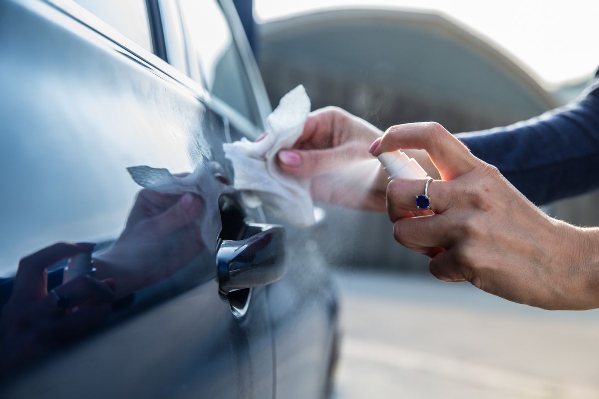 Spraying Hand sanitizer on car door handle (Getty Images/Stock Photo)