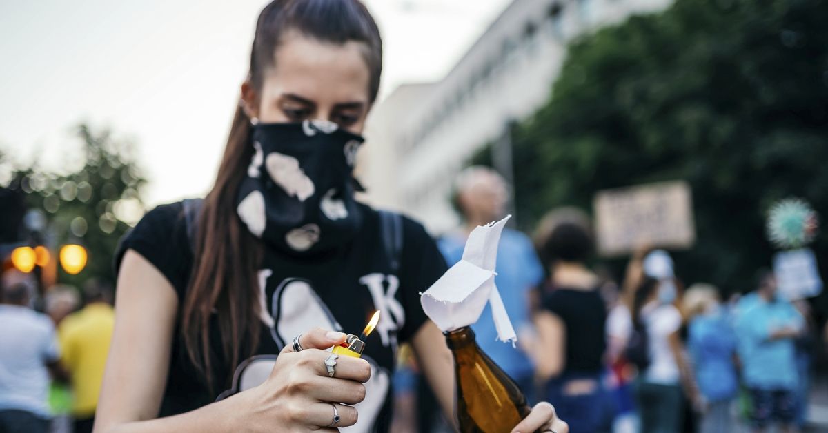 Young female protester lights Molotov cocktail (Getty Images/Stock Photo)