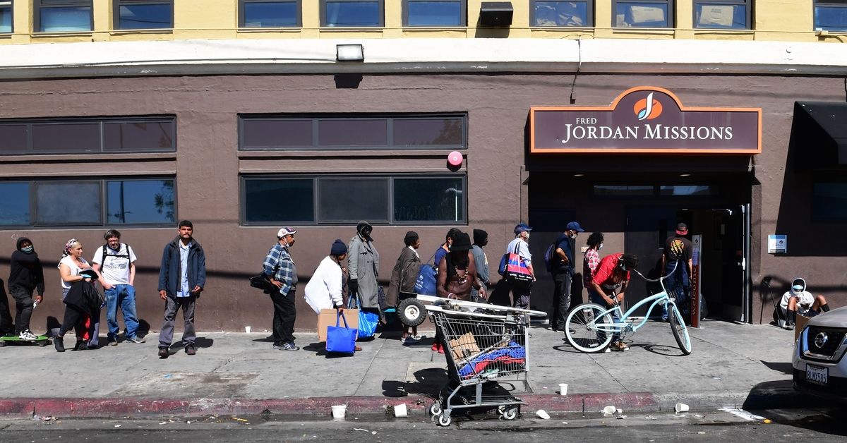 Homeless people wait in line for a morning meal at the Fred Jordan Missions Los Angeles, California on April 22, 2020, amid the novel coronavirus pandemic. - Los Angeles, the city with one of the largest homeless populations in the country, is trying to move 15,000 homeless individuals to hotels or emergency shelters in an effort to prevent the spread of COVID-19, amid the novel coronavirus pandemic. (Photo by Frederic J. BROWN / AFP) (Photo by FREDERIC J. BROWN/AFP via Getty Images) (FREDERIC J. BROWN/AFP via Getty Images)