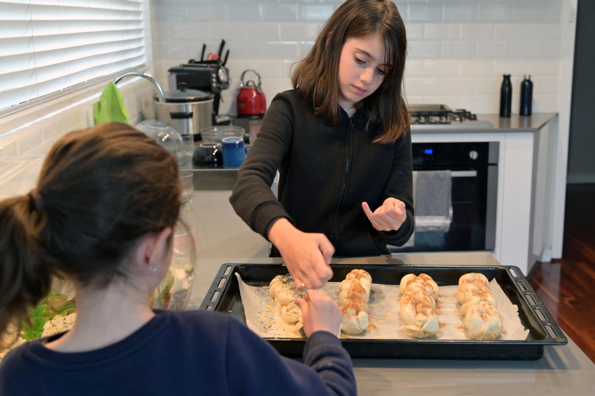 Two young Jewish girls (females age 07 and 11) baking challah bread in home kitchen for Sabbath Jewish holiday dinner. (Getty Images)