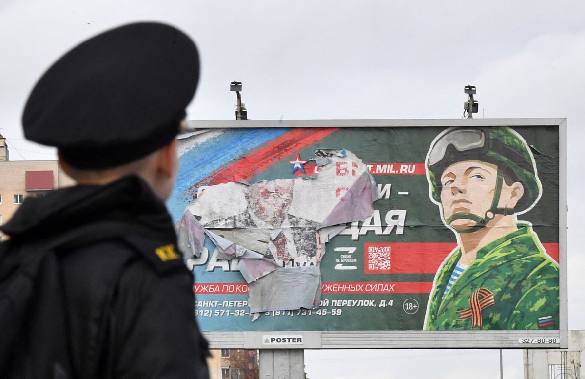 TOPSHOT - A military cadet stands in front of a billboard promoting contract army service in Saint Petersburg on October 5, 2022. - Russian President Vladimir Putin announced on September 21 a mobilisation of hundreds of thousands of Russian men to bolster Moscow's army in Ukraine, sparking demonstrations and an exodus of men abroad. (Photo by Olga MALTSEVA / AFP) (Photo by OLGA MALTSEVA/AFP via Getty Images) (Getty Images)