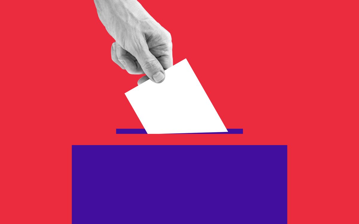 The human hand drops the ballot into the box. (Getty Images)