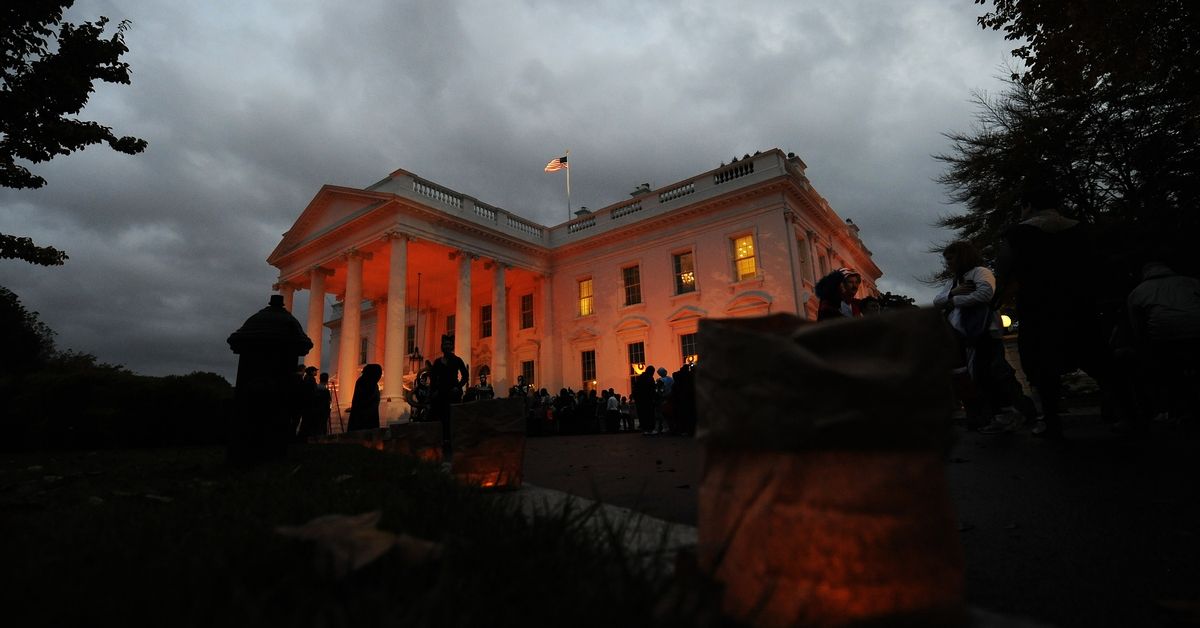 The White House is lit with orange light as people gather at the North Portico of the White House in Washington on October 31, 2009. US President Barack Obama and First Lady Michelle Obama will greet more than 2,000 children from Washington, Maryland and Virginia schools and their families to celebrate Halloween. AFP PHOTO/Jewel SAMAD (Photo credit should read JEWEL SAMAD/AFP via Getty Images) (JEWEL SAMAD/AFP via Getty Images)