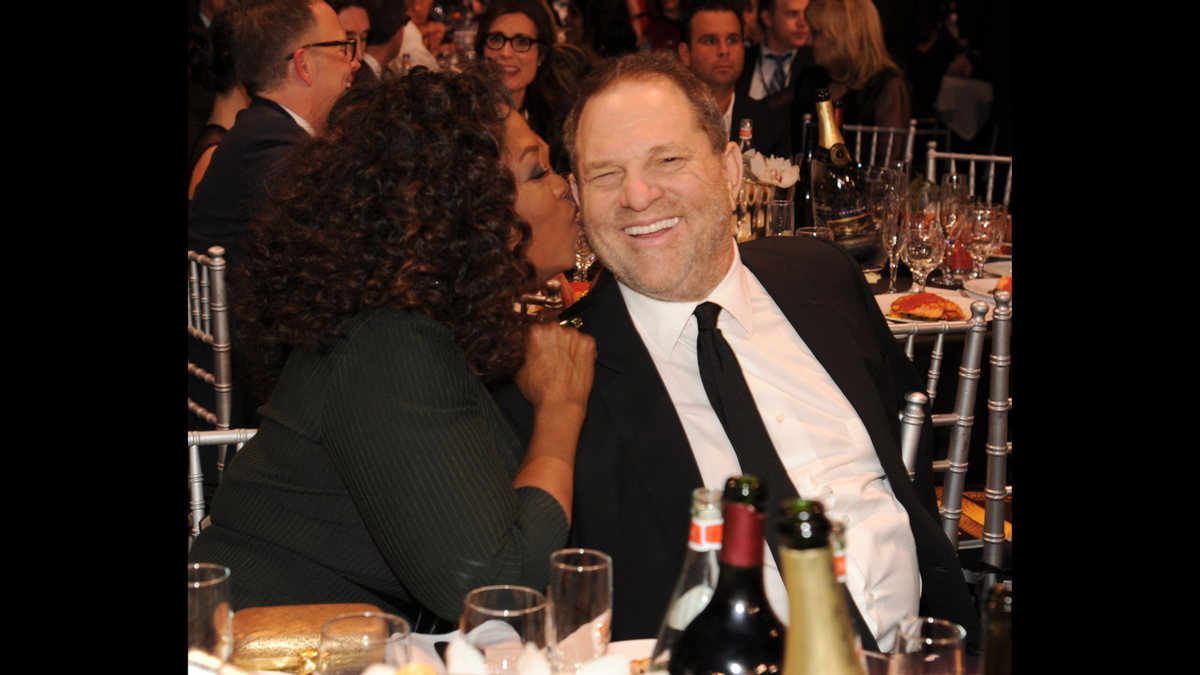 The photograph of Oprah kissing Harvey Weinstein is real, although it was taken several years before Weinstein's alleged sexual misconduct was made public. (Getty Images)
