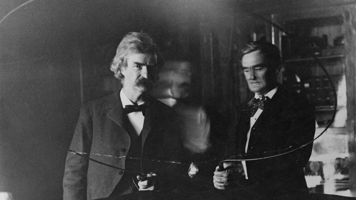 Nikola Tesla (blurred in center) performs an electrical experiment for author Samuel Clemens (Mark Twain) and actor Joseph Jefferson in 1894. (Photo by Kostich/FPG/Archive Photos/Getty Images) (Kostich/FPG/Archive Photos/Getty Images)