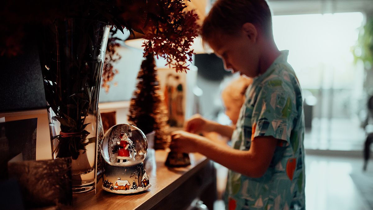 A young boy plays with a Christmas ornament. (Louise Beaumont/Getty Images)