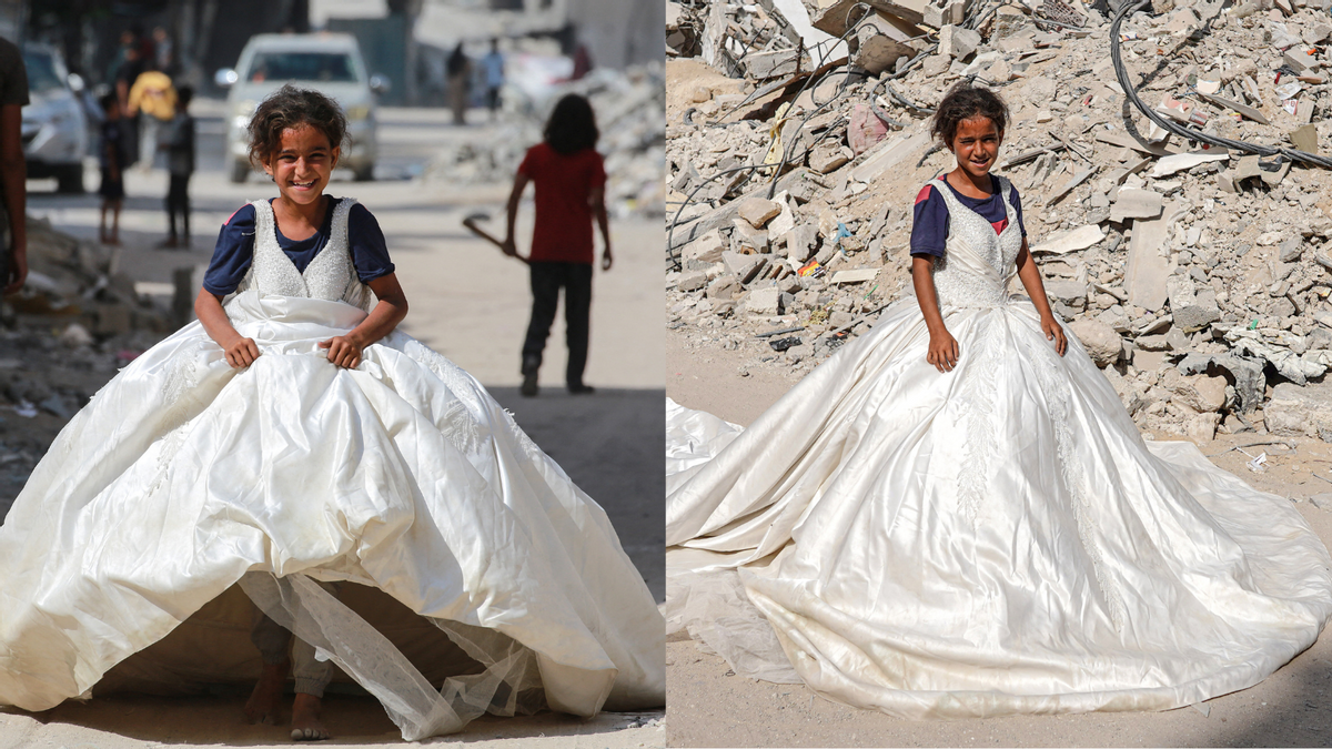 A Palestinian girl posing with a wedding dress found among the rubble in Khan Yunis in the southern Gaza Strip on June 20, 2024. (Getty Images)