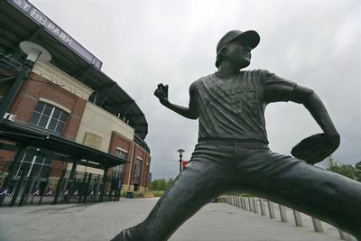 A statue of Atlanta Braves pitcher Phil Niekro stand outside Truist Park, home of baseball's Atlanta Braves, Tuesday, March 31, 2020, in Atlanta. The Braves were suppose to host their home opener on Friday, April 3, but the season's start was postponed by Major League Baseball because of the coronavirus pandemic. (Curtis Compton/Atlanta Journal-Constitution via AP)