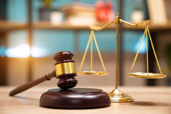 Law and justice concept. Judge's gavel, scales, hourglass, vintage clock, books ( Witthaya Prasongsin/Getty Images/stock photo)