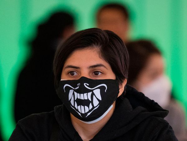 A woman wears a face mask to protect against the COVID-19 (Coronavirus) after arriving at the LAX airport in Los Angeles, California on March 5, 2020. - California has declared a state of emergency as the number of novel coronavirus cases and deaths in the US continues to climb. (Photo by Mark RALSTON / AFP) (Photo by MARK RALSTON/AFP via Getty Images) ( MARK RALSTON/AFP via Getty Images)