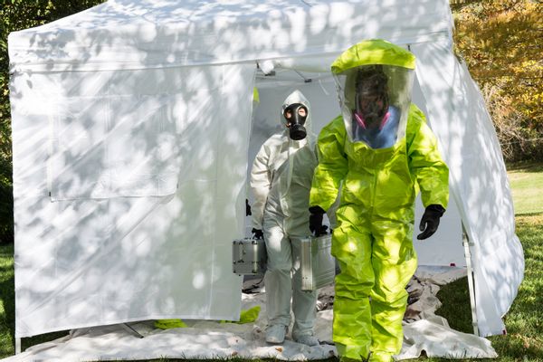 Two healthcare workers depart to the scene dressed in their hazmat gear. (Getty Images)