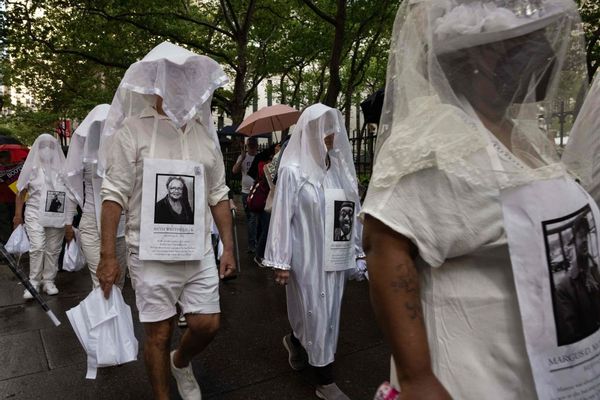 TOPSHOT - Demonstrators from "Gays against Guns" wear portraits of the victims as they march during a silent procession after the mass shooting in the city of Buffalo, near Times Square in New York on May 16, 2022. - The teenager charged with shooting dead 10 African Americans at a supermarket in Buffalo, New York followed an insidious racist creed gaining ground among white Americans that minorities are taking over society. (Photo by Yuki IWAMURA / AFP) (Photo by YUKI IWAMURA/AFP via Getty Images) (Getty Images)