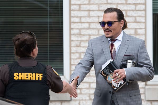 FAIRFAX, VA - MAY 26: (NY &amp; NJ NEWSPAPERS OUT) Johnny Depp shakes hands with a Sheriffs deputy as he departs outside court during the Johnny Depp and Amber Heard civil trial at Fairfax County Circuit Court on May 26, 2022 in Fairfax, Virginia. Depp is seeking $50 million in alleged damages to his career over an op-ed Heard wrote in the Washington Post in 2018.(Photo by Cliff Owen/Consolidated News Pictures/Getty Images) (Cliff Owen/Consolidated News Pictures/Getty Images)