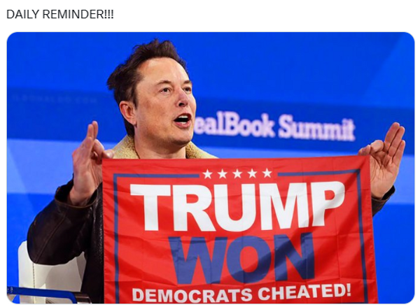 A white man holds a flag that says, &quot;Trump won, Democrats cheated!&quot; 