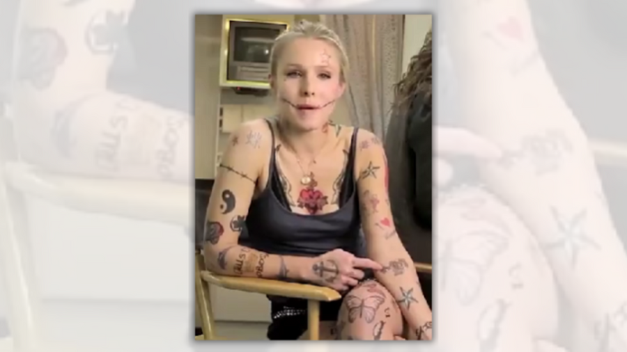 A white woman wearing a black tanktop is heavily tattooed.