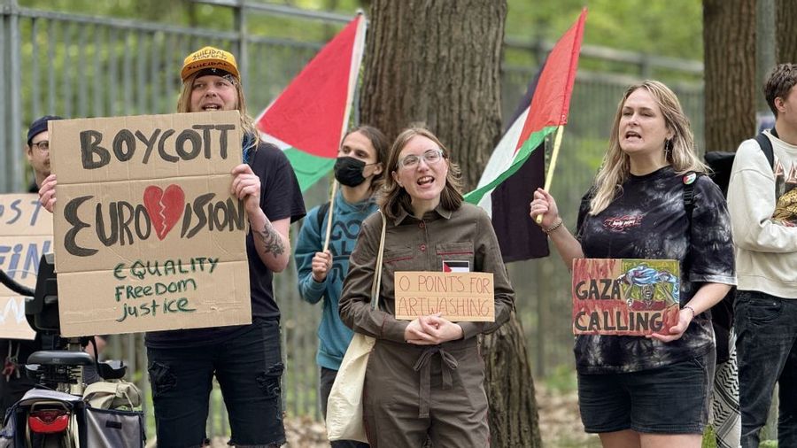 White people hold signs and hold Palestinian flags while boycotting Israel being part of Eurovision.